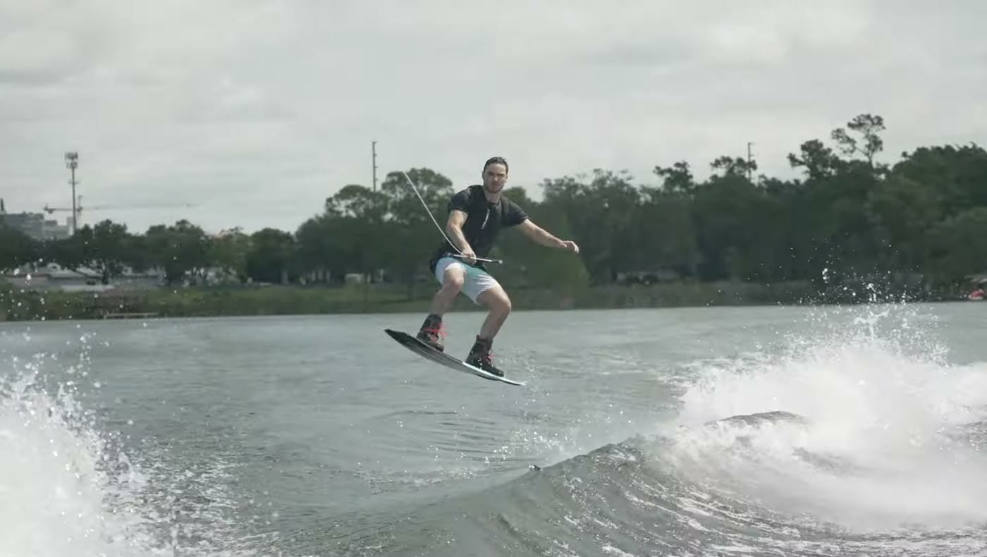 A man is riding a wakeboard on a river.