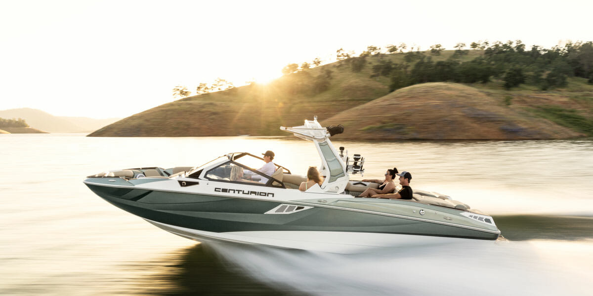 A group of people wakesurfing on a wakeboat.