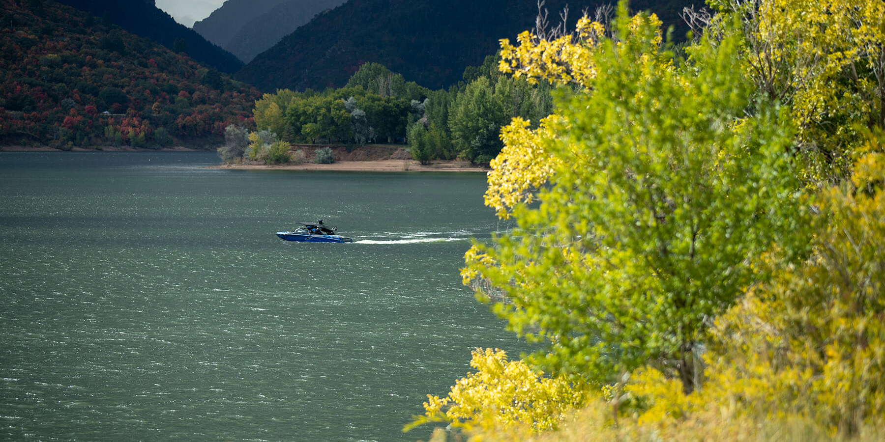 A boat on a lake near a mountain.