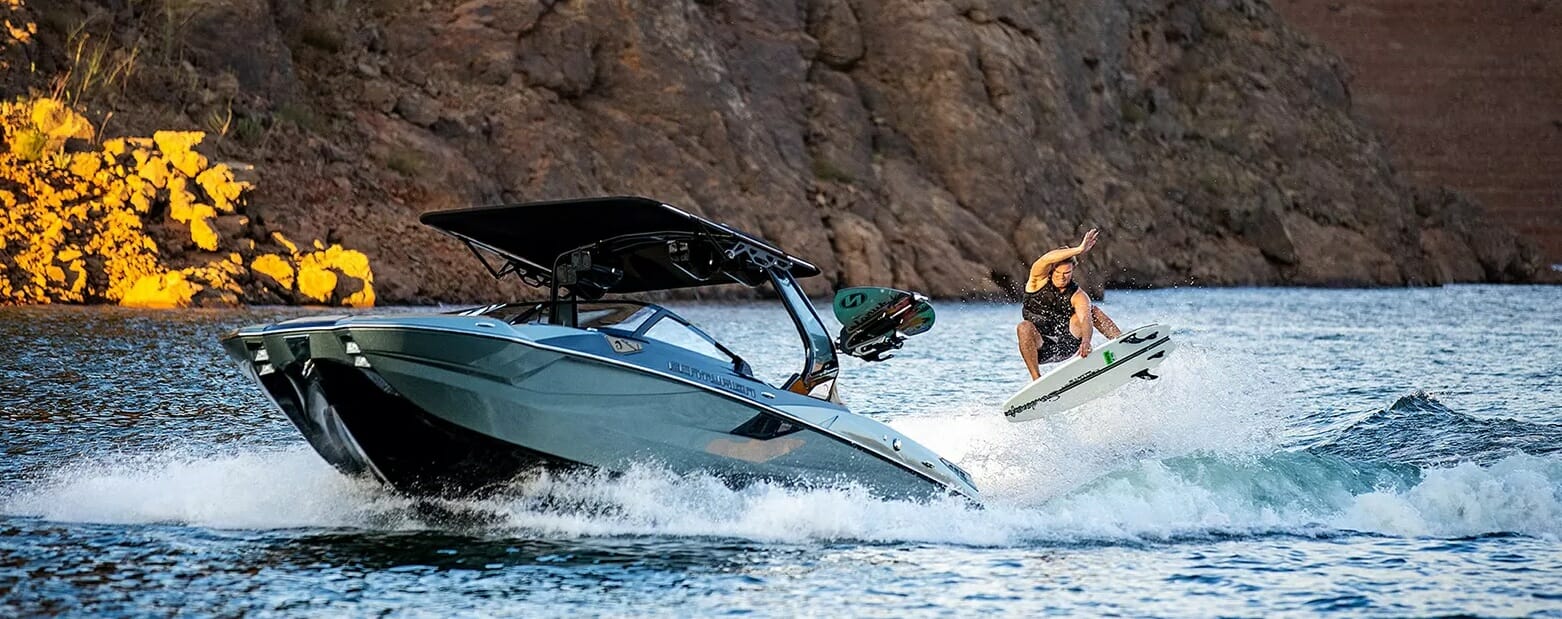 A man is riding a wakesurf board on a boat.