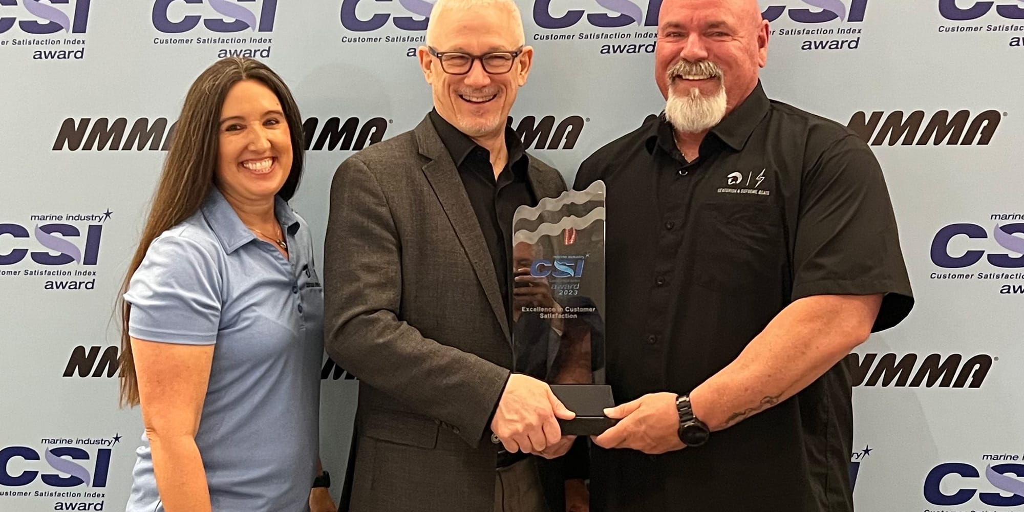 Three people standing in front of a Centurion Boats Customer Satisfaction Award sign.