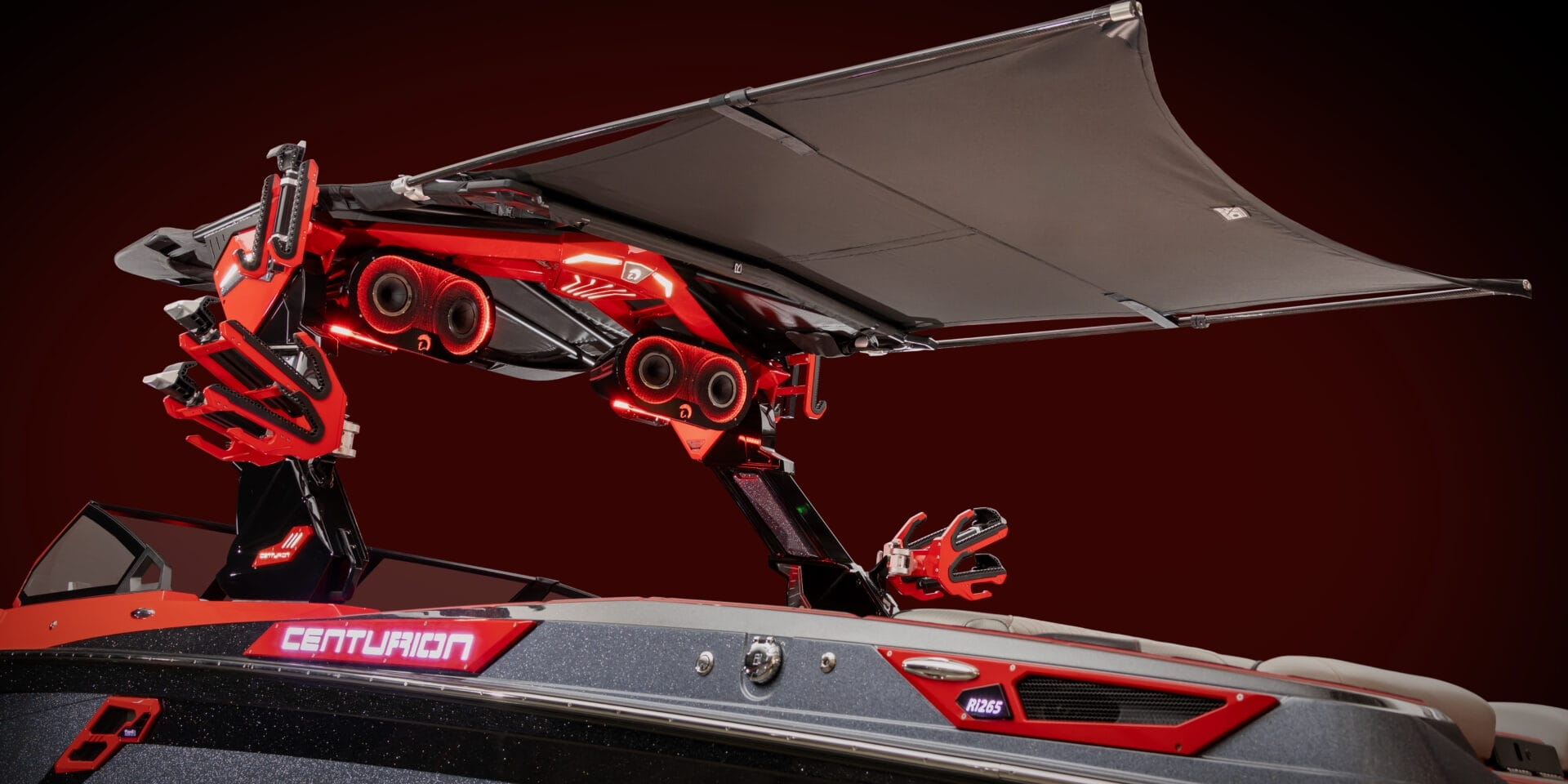 A red and black boat features advanced overhead equipment with an extended canopy. The boat's brand name, 