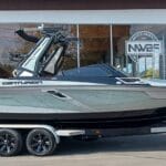 A sleek Centurion boat on a trailer is parked in front of a building with a glass entrance.