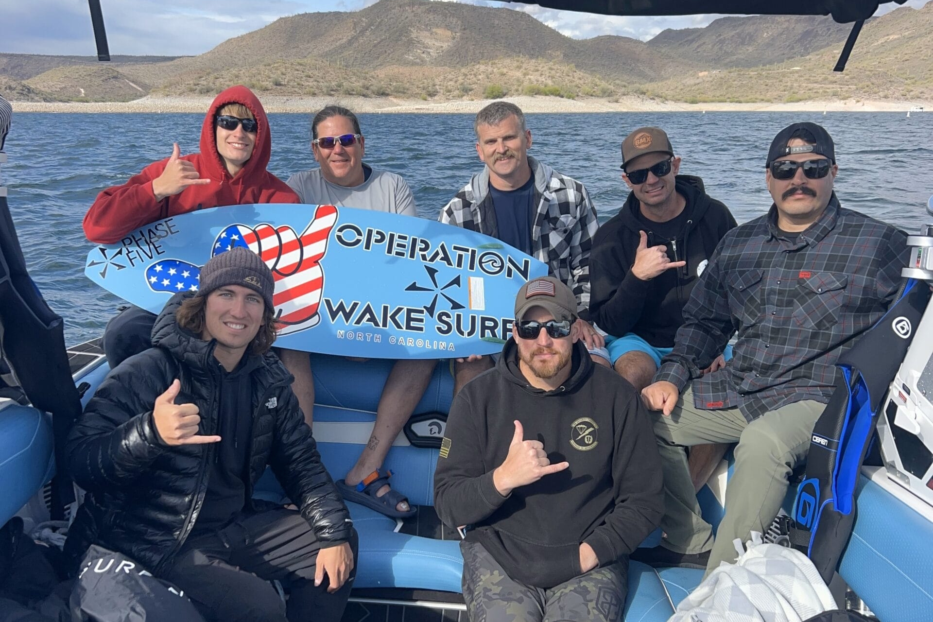 Group of seven men on a boat holding a 