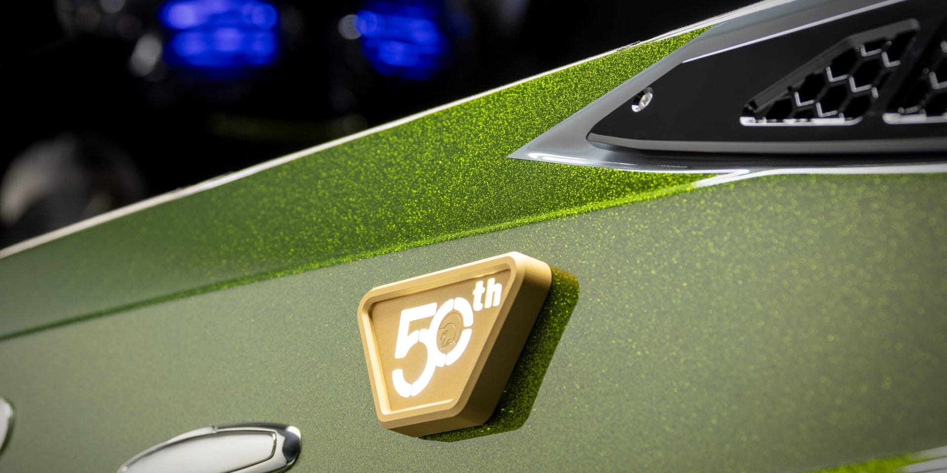 Close-up of a green metallic car with a gold 