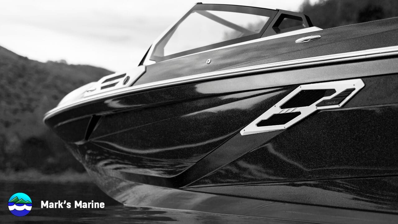 Close-up, side view of a sleek, modern speedboat on the water; hills in the background; Mark’s Marine logo and name in the lower left corner.