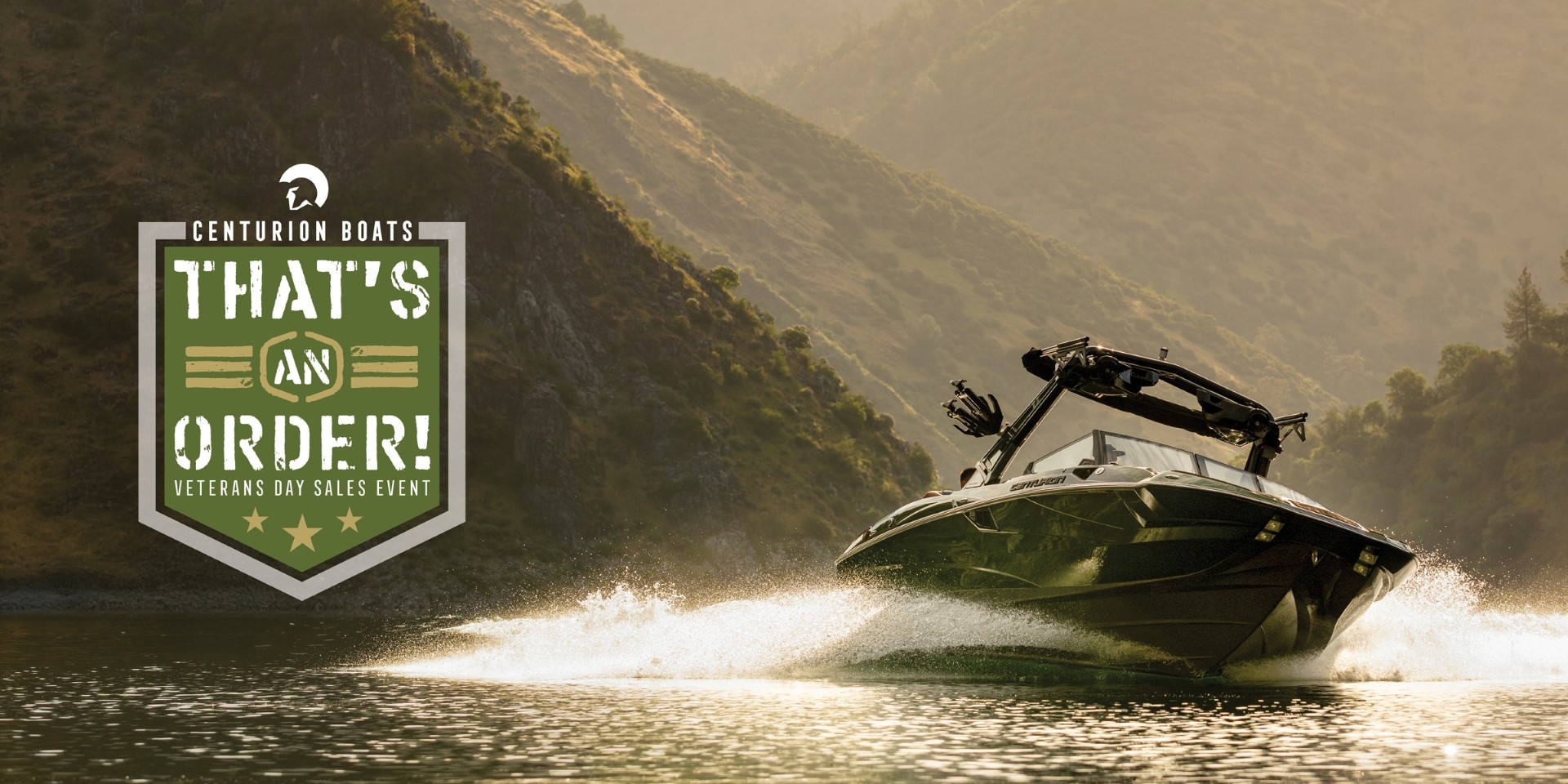 Speedboat moves quickly on a lake with mountains in the background; on the left, a Centurion Boats Veterans Day Sales Event badge reads “That’s an Order!”.