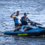 Two men riding a jet ski.