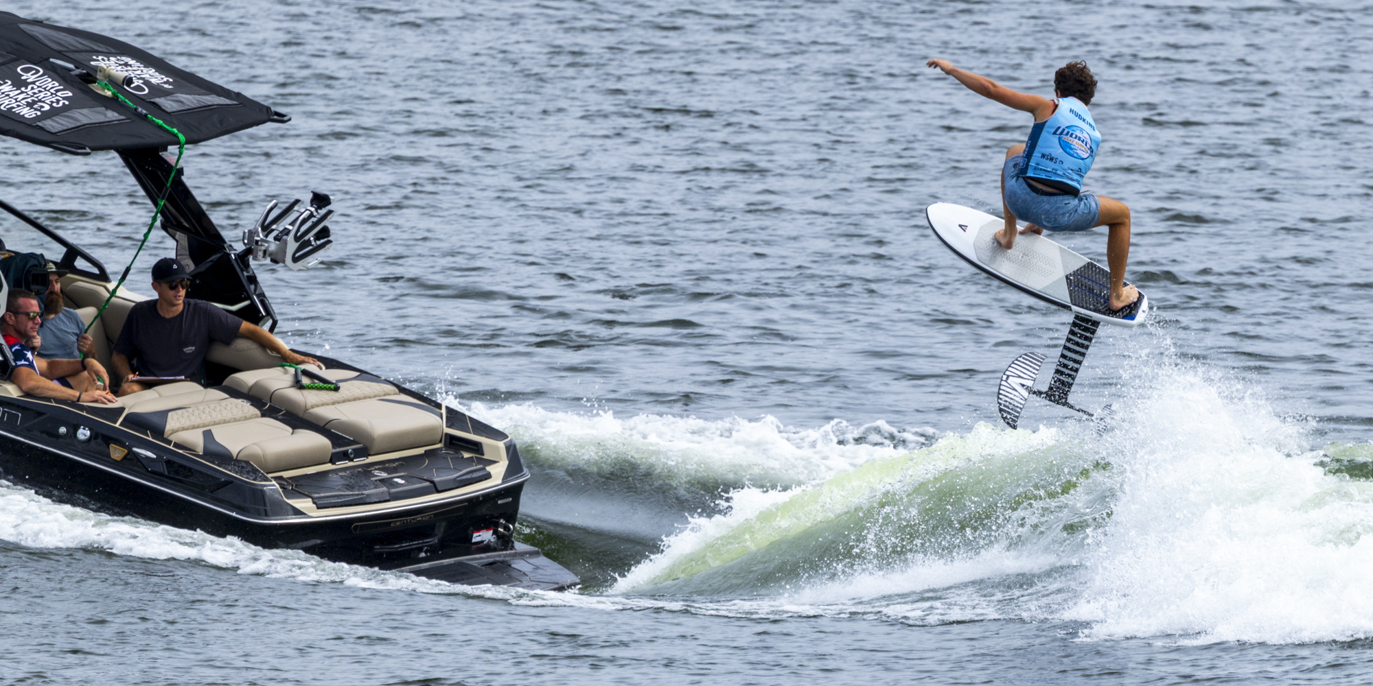 A person on a surfboard jumping off a boat.