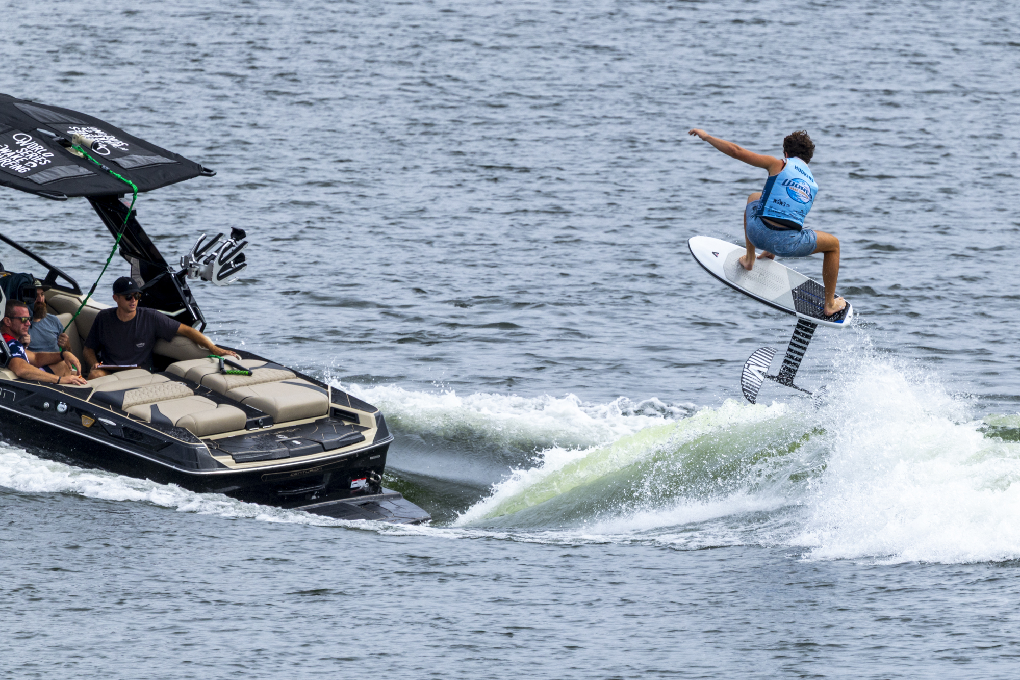 A person on a surfboard jumping off a boat.
